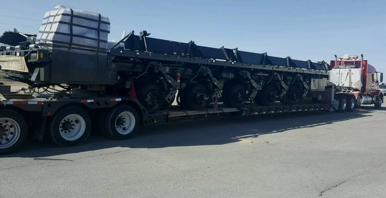 Machinery loaded across a multi-axle trailer